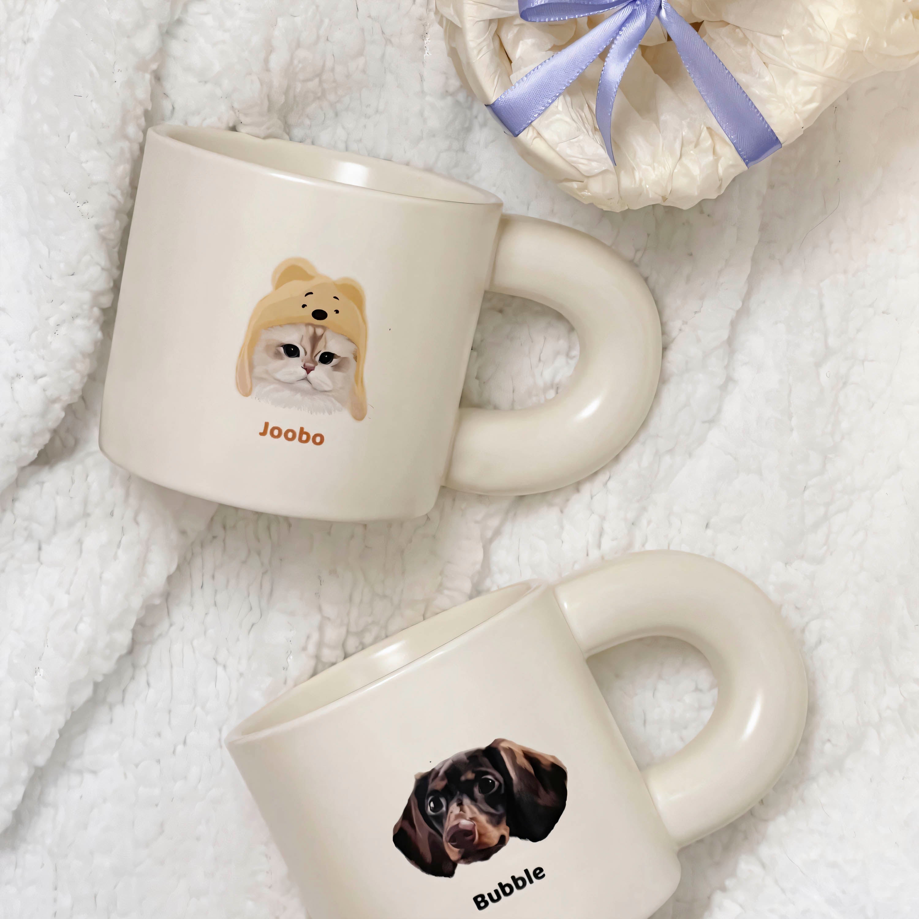 Two custom pet portrait mugs, one featuring a cat wearing a bear hat named ‘Joobo’ and the other with a dachshund dog named ‘Bubble